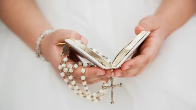 close-up-child-hands-holy-communion